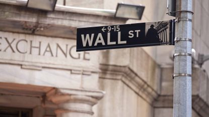 Wall Street street sign with New York Stock Exchange building in background
